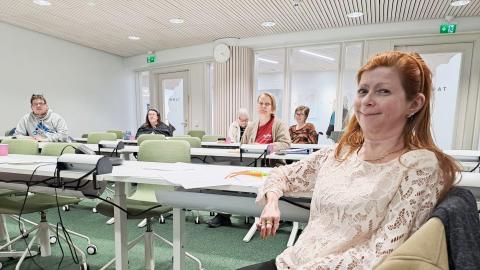 Tampereen vammaisneuvoston puheenjohtaja Katja Metsävainio istuu neuvoston kokouksessa. Hänen takanaan näkyy etäällä muita kokouksen osallistujia.