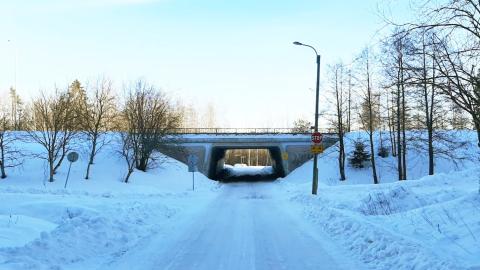 Kuvass luminen maisema, tie joka risteää pyörätietä ja alikulku, ennen sitä STOP-merkki.