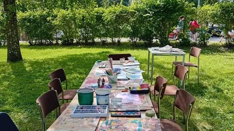 Painting tables and supplies in the middle of the park.