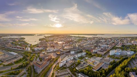 Tampereen kaupungista ilmakuva, jossa näkyy keskustan rakennuksia ja puistoja sekä taustalla Näsijärvi ja Pyhäjärvi.