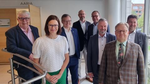 Eight city leaders standing next to each other in Tampere Hall.