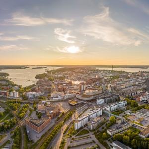 Tampereen kaupungista ilmakuva, jossa näkyy keskustan rakennuksia ja puistoja sekä taustalla Näsijärvi ja Pyhäjärvi.