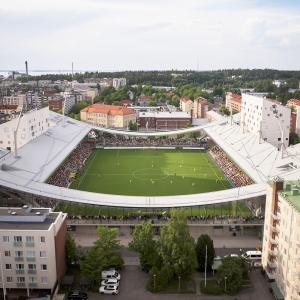 Tammela Stadium photographed from the air so that the pitch is visible in the middle of residential buildings, highlighting the shape of the stadium and the curved main structures.