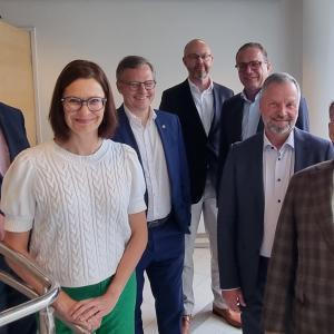 Eight city leaders standing next to each other in Tampere Hall.