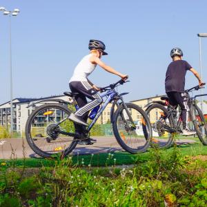 Poikia pyörineen pumptrack-radalla.