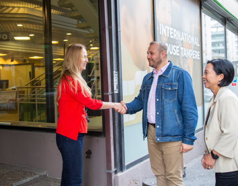 Advisor and customer are shaking hands in front of the International House Tampere.
