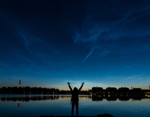 Night view of the city of Tampere. Person is standing towards a lake.