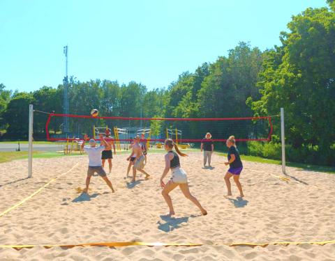 Young people playing beach volleyball.