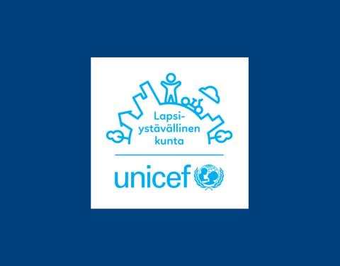 Unicefin Lapsiystävällinen kunta -tunnuksessa on piirretty kaari, jossa erottuu lapsen hahmo kaupungin keskellä. Sen alapuolella on teksti Lapsiystävällinen kunta. Kuvan vieressä on Unicefin nimi ja logo.