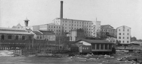 Mustavalkoinen kuva Finlaysonin tehtaista Tammerkoskelta päin.